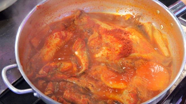 냄비에서 졸이고 있는 각종 생선이 들어있는 생선찜
