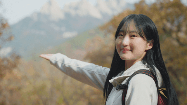 Young woman smiling while enjoying autumn mountain scenery