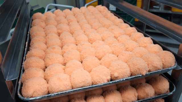Pink rice cake being prepared on a tray