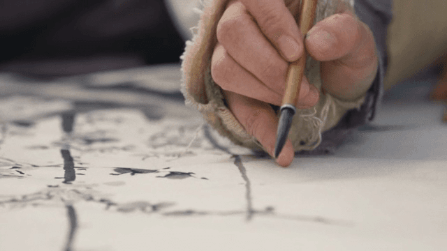 붓으로 종이에 그림을 그리는 사람