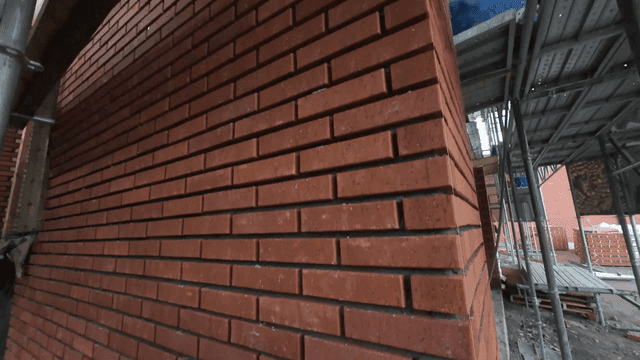 Brick wall under construction with scaffolding