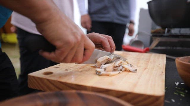 Preparing fresh abalone and clams on a wooden cutting board