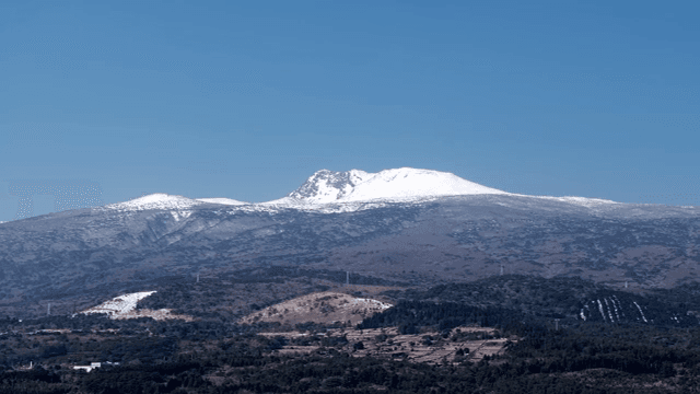 Snow-capped Hallasan mountain under clear blue sky