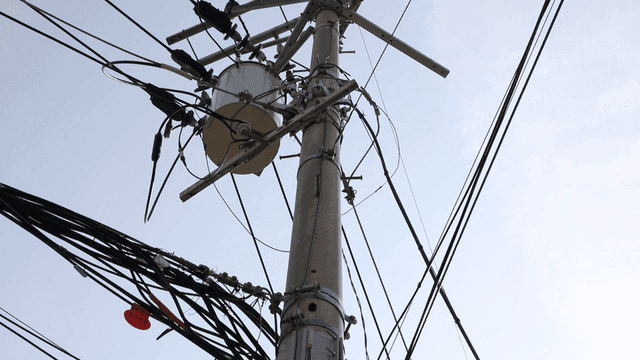 Utility pole with wires against the sky