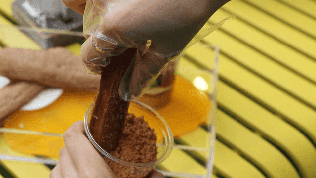 Churros being dipped in dessert cups