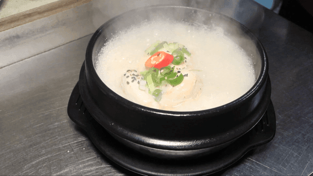 Steaming hot pot of ginseng chicken soup on a table
