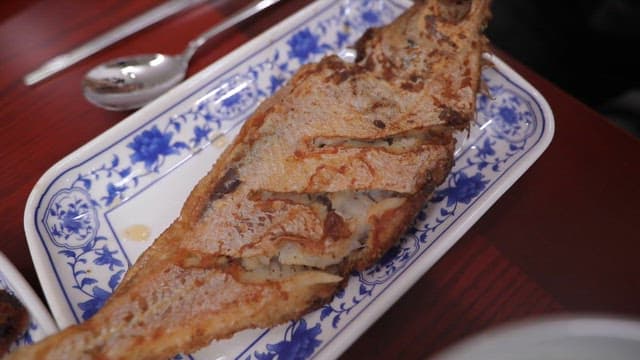 Plates of delicious grilled fish on wooden tables