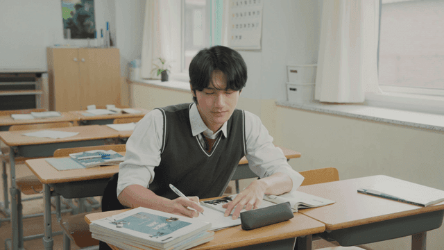 홀로 남아 교실에서 공부하다 하품하고 스트레칭하는 학생