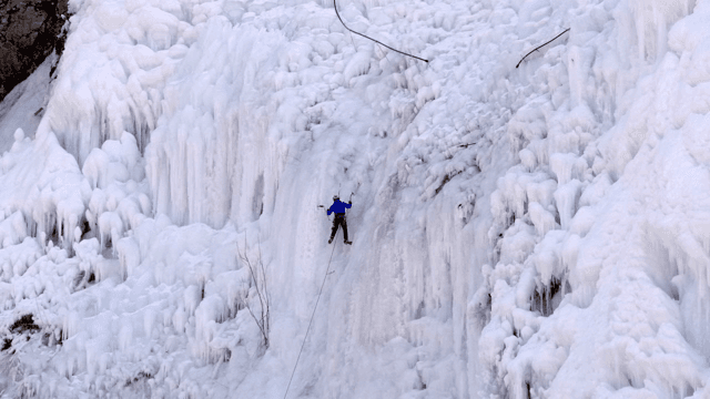 얼어붙은 폭포를 오르는 아이스 클라이머