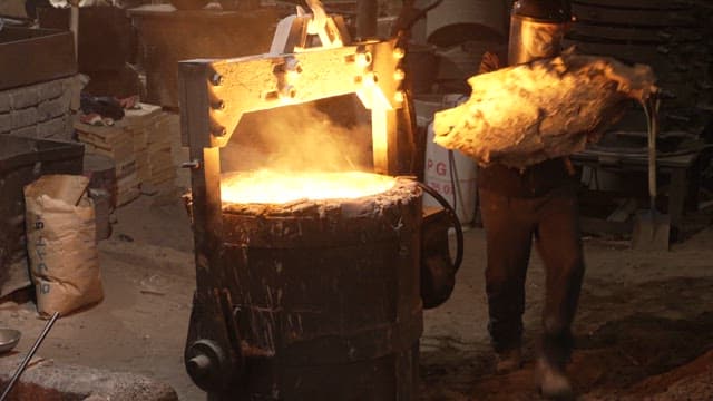 Worker handling molten metal in a foundry