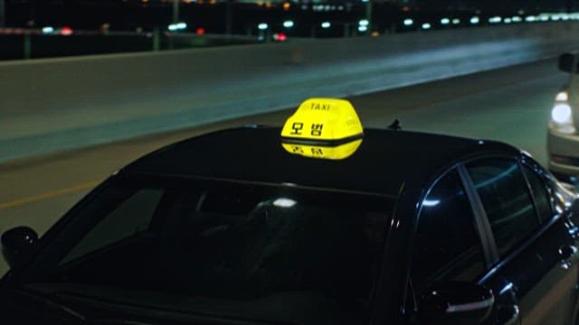 밤에 도로를 달리는 모범택시와 자동차들