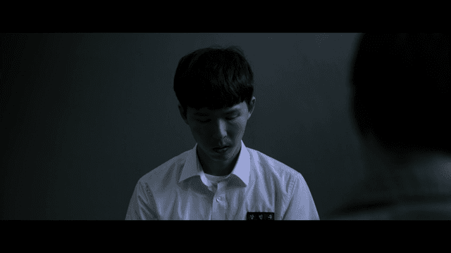 Male student being interrogated in dark room