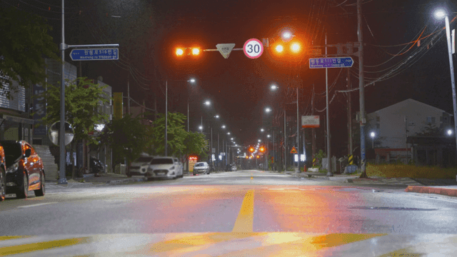 밤에 주황색 신호등이 있는 빈 도로