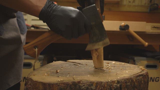 실내에서 도끼로 나무를 자르는 모습