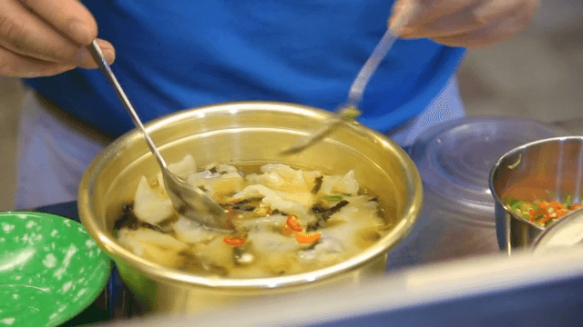 Person who adds chili peppers to hand-pulled dough soup