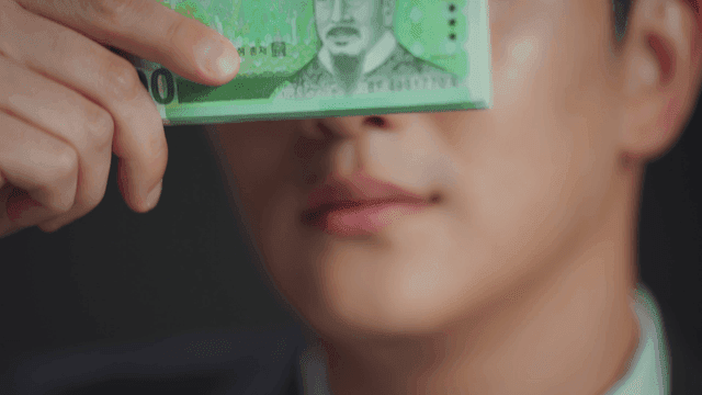 돈으로 눈을 가린 채 웃고 있는 남자