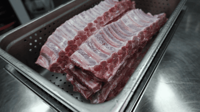Raw pork ribs in metal container