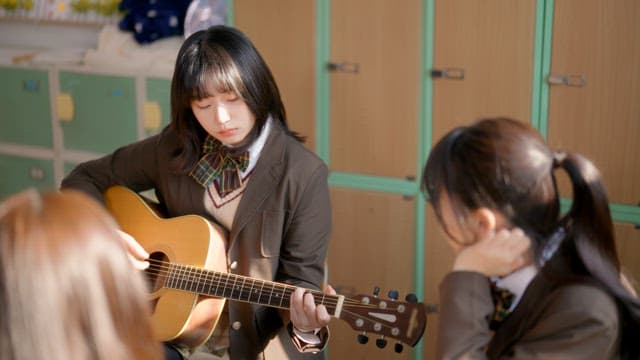 Student playing guitar in a classroom