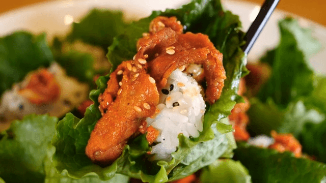 젓가락으로 집어 든 제육 쌈밥