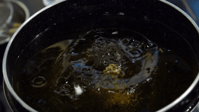 반죽이 묻은 가지를 기름에 튀기는 장면