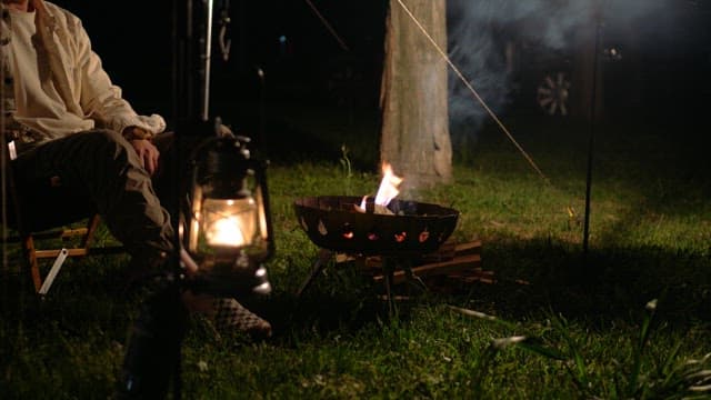 Camping at night with a campfire and lamp