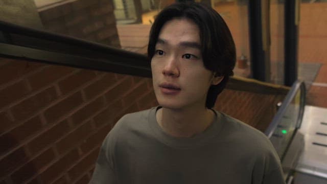에스컬레이터에서 주위를 둘러보는 남성