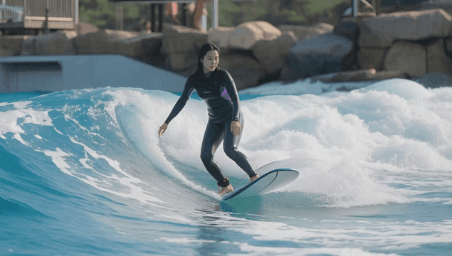 인공 파도에서 서핑하는 여성