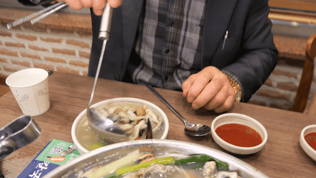 Ladle scooping out hot oyster kalguksu
