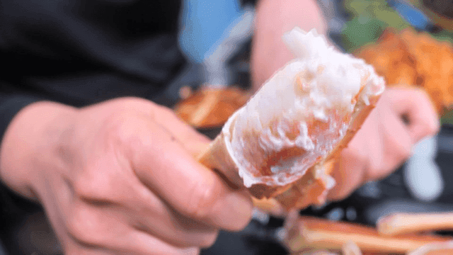 Hands splitting crab legs