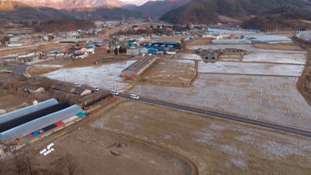 시골의 농경지를 줄지어 달리는 구급차들