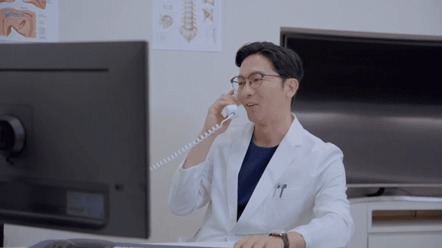 전화를 받고 미소를 짓는 의사