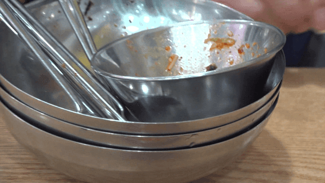 Stacked empty steel bowls on a surface