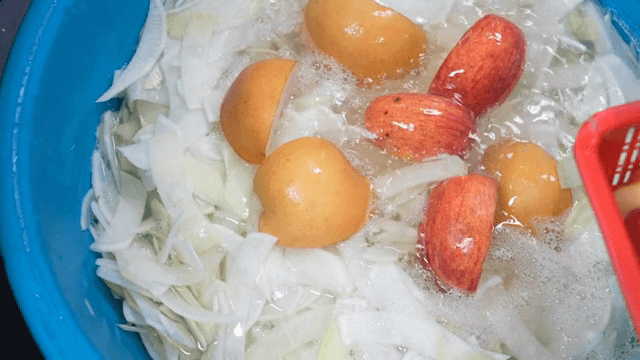 Sliced radish and fruits soaking in water