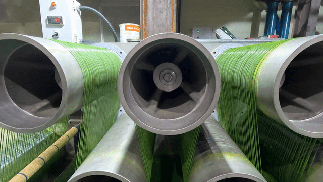 산업용 스풀에 감기는 녹색 실들