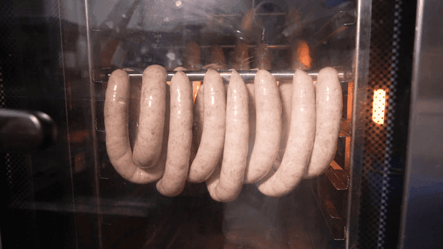 Sausage dripping fat while cooking in smoker oven
