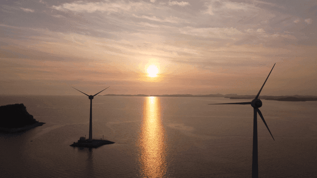 Wind turbines at sunset over the sea