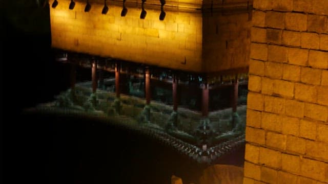 밤에 불이 켜진 물에 반사된 전통 건축물