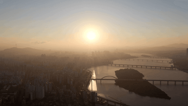 Sunrise over a city with a river and bridges