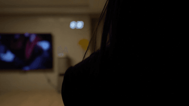 Back of woman walking out into living room of her house