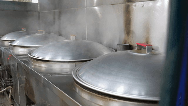Steam rising from large cooking pots