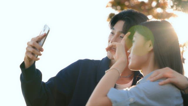 Couple taking selfies in a park