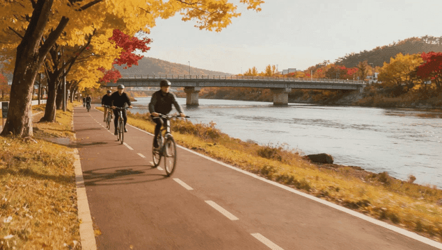 People cycling along autumn riverside path