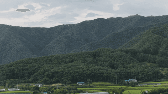 Lush green mountains under a cloudy sky