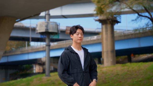 Man standing under a highway bridge