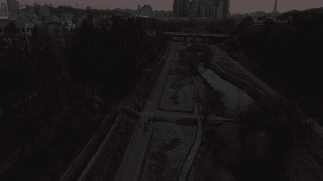 Cityscape with people jogging along river and walking path