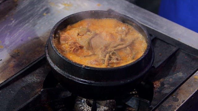 Duck soup boiling in an earthen pot