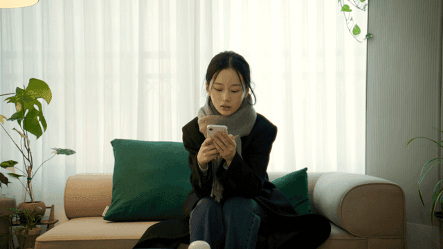 Woman sitting on sofa using cell phone1