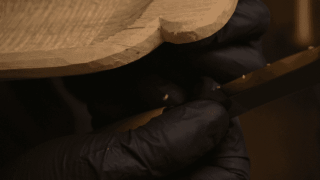 정교한 칼로 나무 조각을 다듬는 장인