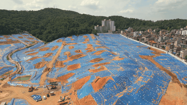 Large construction site with blue tarps
