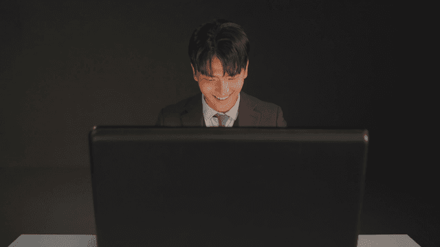 서류 가방을 열자 미소 짓는 정장을 입은 남자